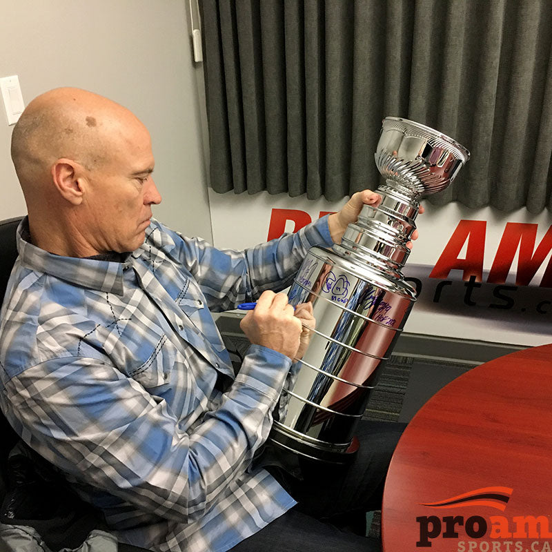 Mark Messier signing an NHL Stanley Cup replica during a private signing at Pro Am Sports in Edmonton 