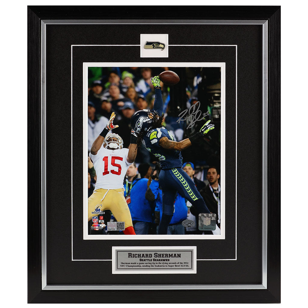 Framed sports memorabilia featuring a football player catching a ball with a signature on a black background