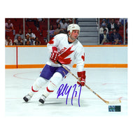 signed photo of Paul Coffey Team Canada Skating during a game wearing white Team Canada jersey. He is looking to the left down the rink. Photo is signed in the lower center in blue ink.