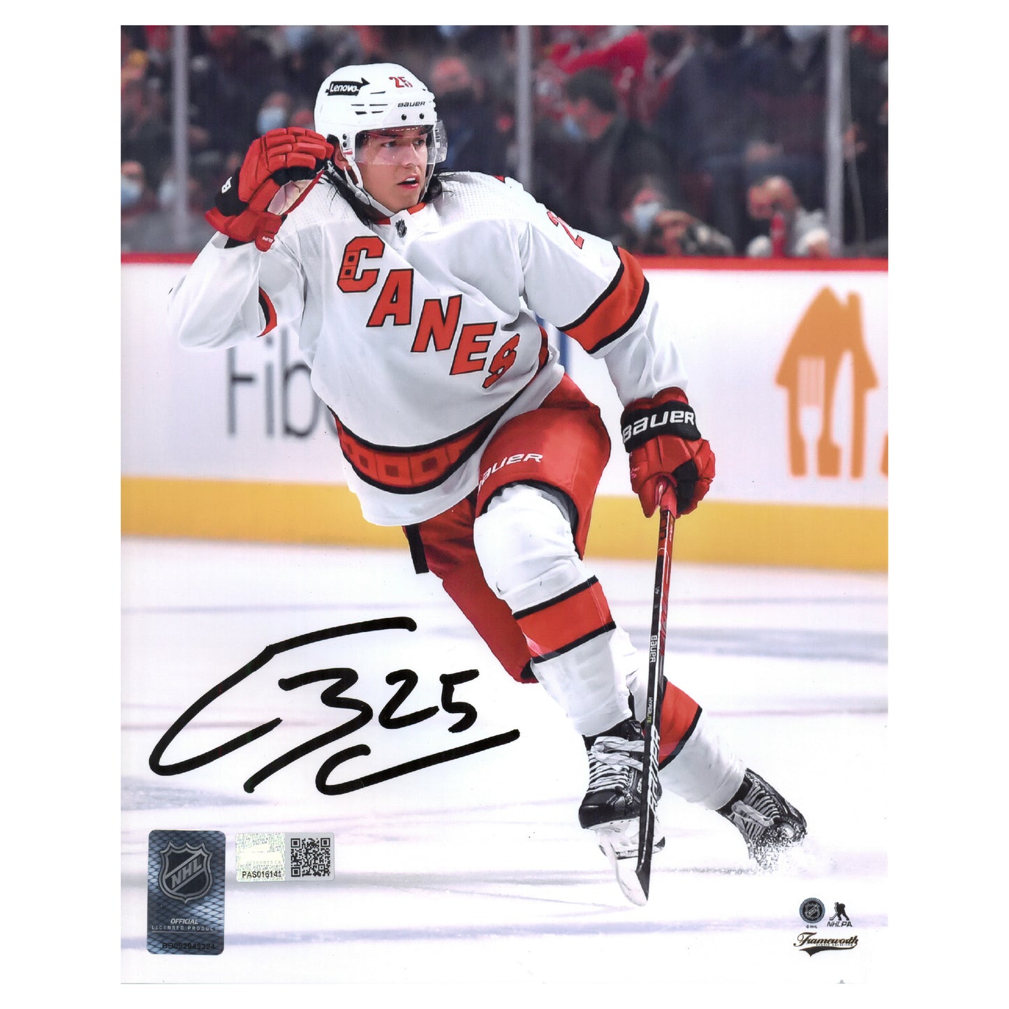 Signed photograph of Ethan Bear Carolina Hurricanes skating in an NHL hockey game wearing white and red Hurricanes away jersey. Signed in lower left corner with authenticity holographs