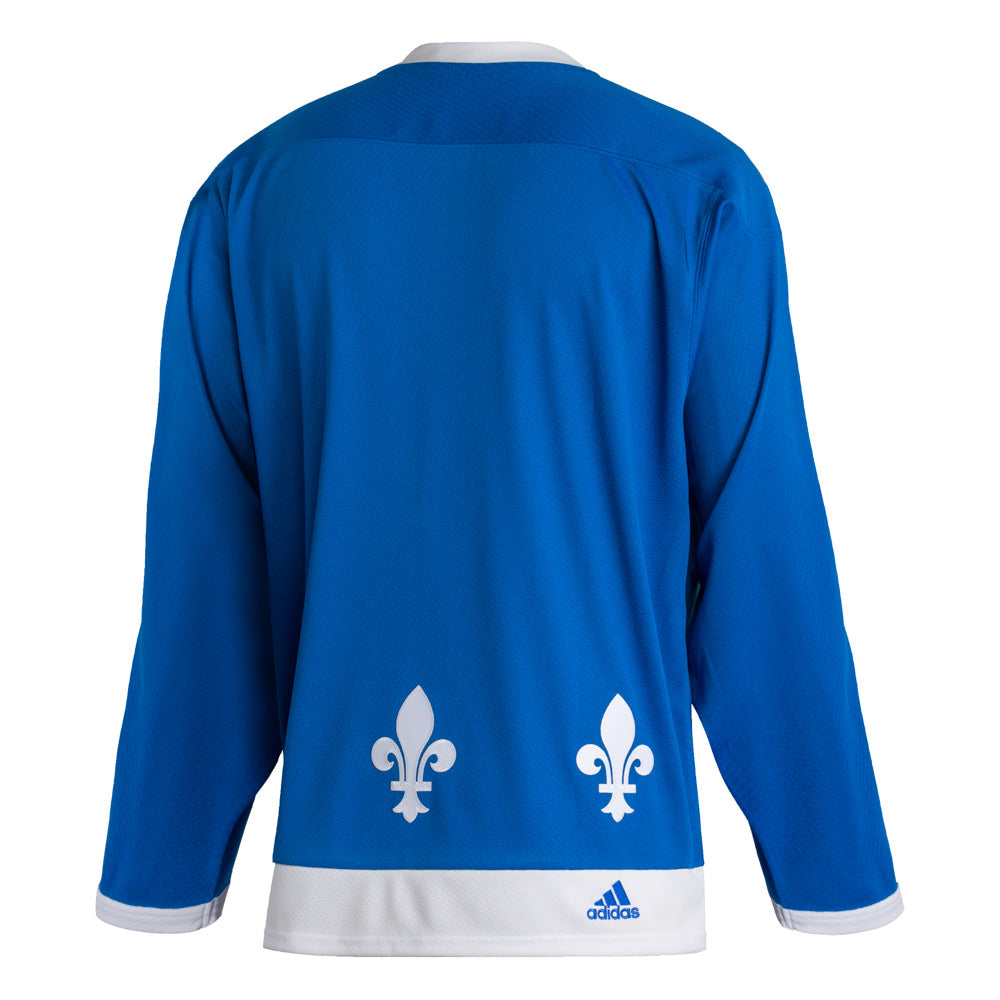 Back view of the adidas vintage team classics 1979 Quebec Nordiques jersey. fleur de lis along the bottom hem. JErsy body is blue with white hems and collar. there is a small embroidered adidas logo on the right side of the bottom hem.