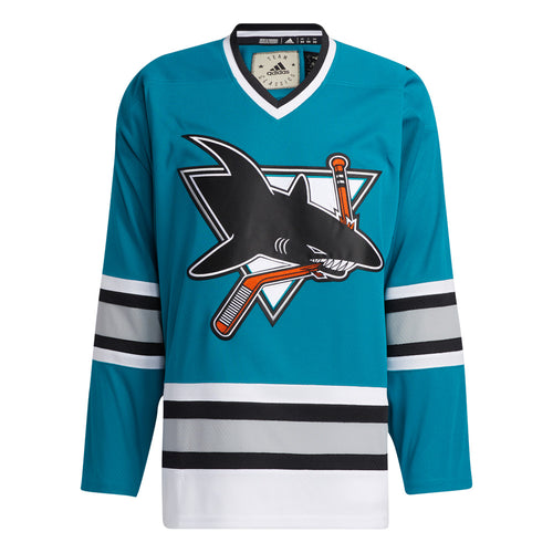 Front view of the adidas vintage team classics  1991 San Jose Sharks jersey featuring bright teal body and logo of shark biting a hockey stick. Sleeves and lower hem featuring black. light grey and white stripes 