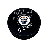 Black NHL hockey puck with Edmonton Oilers logo, puck is signed by Kevin Lowe with "5 Cups" inscription.