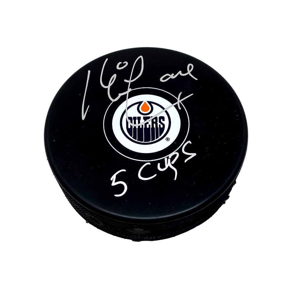 Black NHL hockey puck with Edmonton Oilers logo, puck is signed by Kevin Lowe with "5 Cups" inscription.