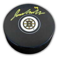 Black NHL hockey puck with Boston Bruins logo; puck has been signed by Jake Debrusk in yellow ink.