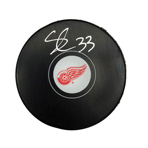 Black NHL hockey puck with Detroit Red Wings Logo, puck is signed by Sebastian Cossa. 