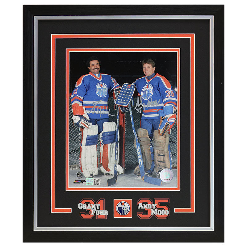 Framed photograph of two hockey players Grant Fuhr and Andy Moog in blue jerseys with visible numbers and names.