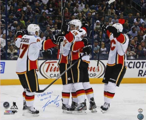 Sean Monahan and teammates celebrating on ice after his first NHL goal with the Calgary Flames. Photo is signed by Monahan in blue in with the inscription "1st NHL Goal"
