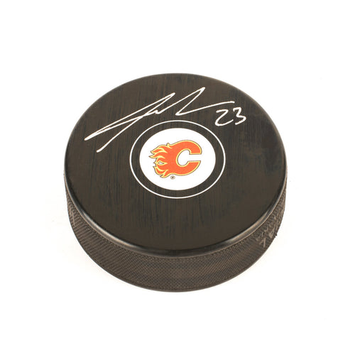 Black NHL hockey puck with Calgary Flames logo. Signed by Sean Monahan. 