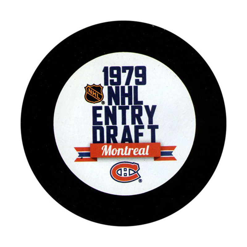 Front view of black hockey puck with large white blue and read 1979 NHL Entry Draft in Montreal design featuring Montreal Canadiens and NHL shield logos
