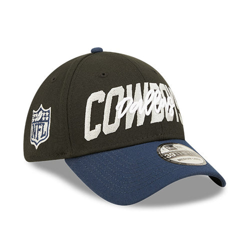 Angled front view of 2022 Dallas Cowboys NFL Draft cap from New Era. Design features embroidered team name on front panels; body of cap is constructed in black with contrasting team colour brim and embroidery.