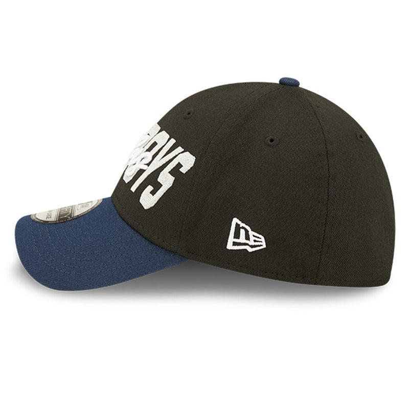 Left side view of 2022 Dallas Cowboys NFL Draft cap from New Era. Design features embroidered team name on front panels; body of cap is constructed in black with contrasting team colour brim and embroidery. 