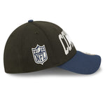 Right side view of 2022 Dallas Cowboys NFL Draft cap from New Era. Design features embroidered team name on front panels; body of cap is constructed in black with contrasting team colour brim and embroidery. NFL logo is embroidered on the right side in silver and navy