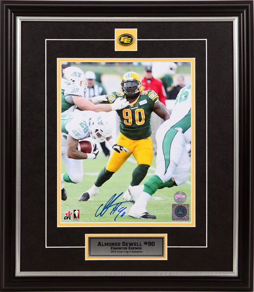 Framed and signed photograph of Almondo Sewell dodging opponents during an Edmonton Elks, Edmonton Football Team, CFL football game with black and silver matting featuring Edmonton Elks crest and descriptive plaque insets