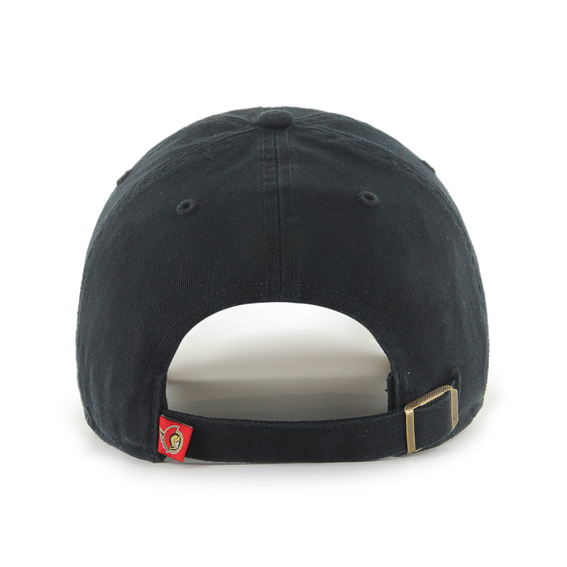 Back view of the Ottawa Senators Black on Black '47 Clean Up Cap, made with black cotton twill. Back features a self-fabric strap with brass buckle for adjustment, and small full colour Senators logo tag. 