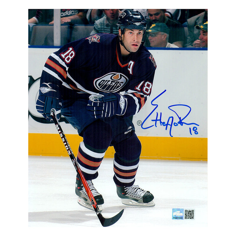 Signed photo of Ethan Moreau Edmonton Oilers skating during NHL hockey game wearing navy jersey; photo is signed in the middle right side in blue. 