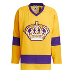 Front view of adidas Vintage team classics 1967 Los Angeles Kings jersey, featuring bold embroidered team logo on front chest and purple bands on sleeves and lower hem, and purple collar. Primary jersey collar is a bright sunshine yell. 
