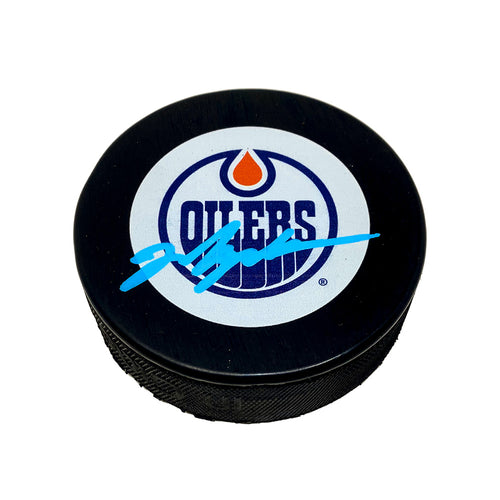 Black hockey puck with Edmonton Oilers vintage 79-80 logo. Puck is signed by Mark Messier in light blue ink 