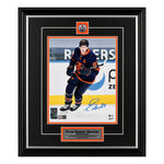 Signed photo of Ryan Nugent-Hopkins skating during an NHL game, wearing navy alternate Edmonton Oilers jersey with alternate captain's "A" on left chest. Framed in black with orange accents in mat design and inset Oilers crest