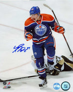 Autographed photo of Ryan Nugent-Hopkins during an Edmonton Oilers home game, opponent on ice behind him. 
