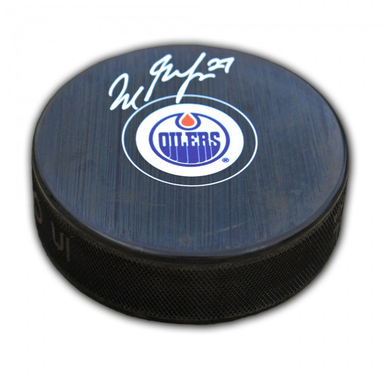 Black NHL hockey puck with Edmonton Oilers logo, signed by Milan Lucic. 