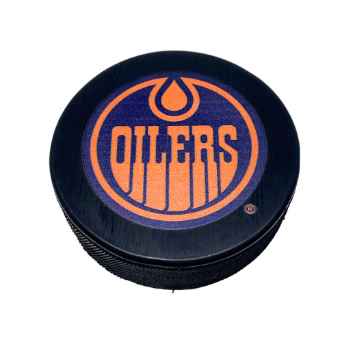 Front view of black hockey puck with Edmonton Oilers navy and orange alternate logo