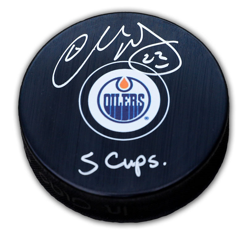 Black NHL hockey puck with Edmonton Oilers logo in middle of the front, signed by Charlie Huddy with "5 Cups" inscription. 