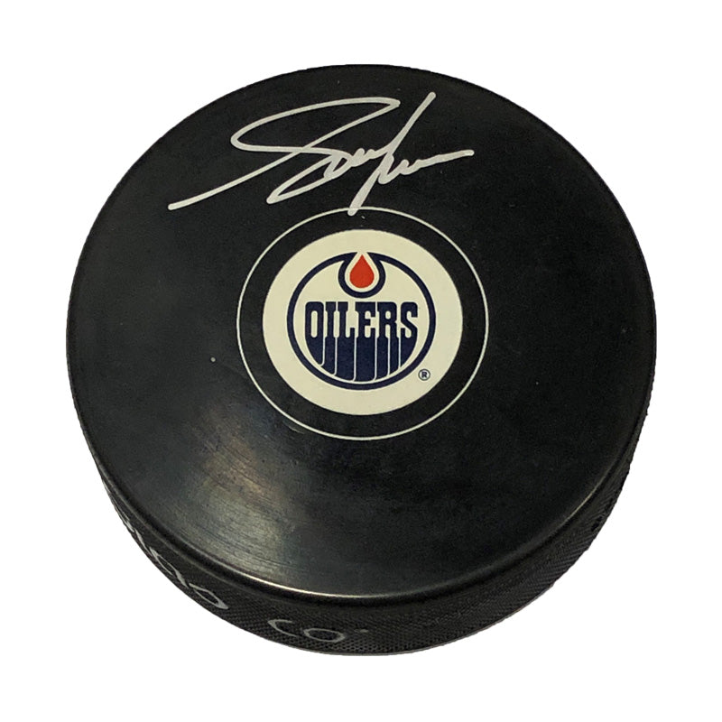 Black hockey puck with oilers logo signed by Adam Graves