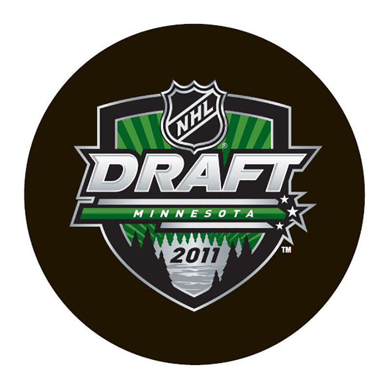 Unsigned black puck with 2011 Minnesota draft design featuring green background in crest and subtle tree and star motifs