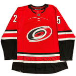 Front view of red Carolina Hurricanes jersey, back side features Ethan Bear cree syllabics with signed jersey number
