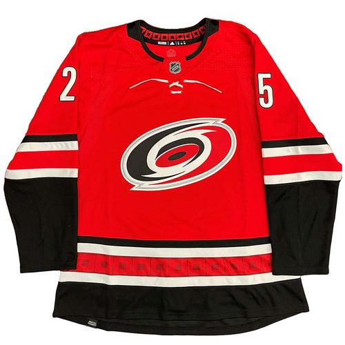 Front view of red Carolina Hurricanes jersey, back side features Ethan Bear cree syllabics with signed jersey number