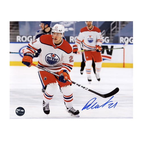 Photo of Edmonton Oiler Dominik Kahun skating during an Edmonton Oilers NHL hockey game while wearing white and orange jersey. Photo is signed in lower right corner. 