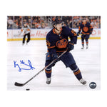 Photo of Edmonton Oiler Kailer Yamamoto skating with puck during an NHL hockey game; he is wearing navy jersey. Photo is signed in blue in the lower left. 