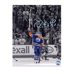 Photo of Edmonton Oiler Ryan Smyth raising his stick in a salute with audience giving standing ovations and some of his teammate skating behind him during his last game. Image is edited so everything but Smyth is in black and white. Photo is signed with blue ink 