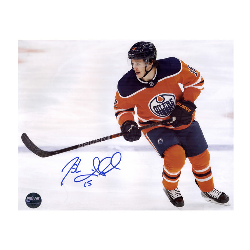 Photo of Edmonton Oilers Josh Archibald skating during an Oilers NHL hockey game, he is wearing orange jersey. Photo is signed in the lower left corner with blue ink. 