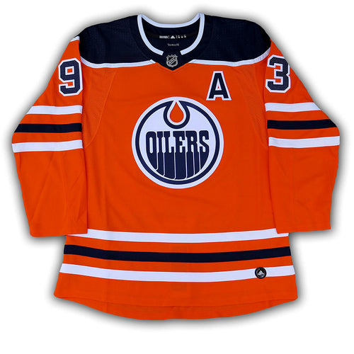 Front view of Ryan Nugent-Hopkins signed Edmonton Oilers orange home jersey. Jersey features alternate captain's "A" on the chest. 