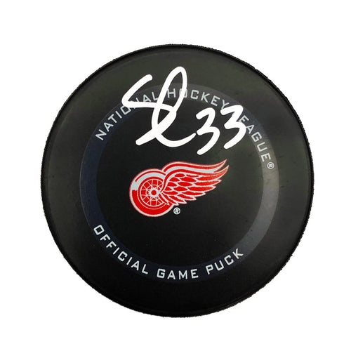 Black NHL Detroit Red Wings Official Game Puck featuring Red Wings logo. Puck is signed by Sebastian Cossa. 