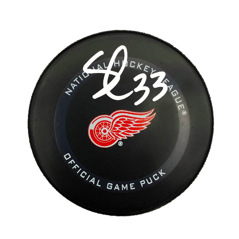 Black NHL Detroit Red Wings Official Game Puck featuring Red Wings logo. Puck is signed by Sebastian Cossa. 