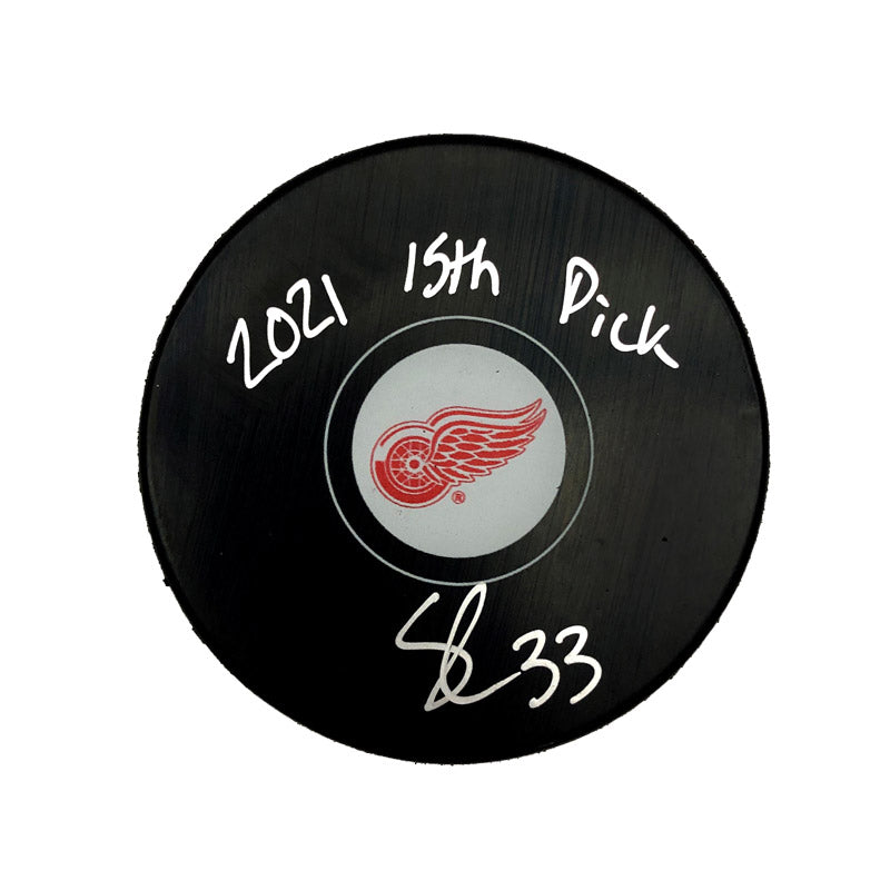 Black NHL hockey puck featuring Detroit Red Wings logo; puck is signed by Sebastian Cossa and inscribed "2021 15th Pick"