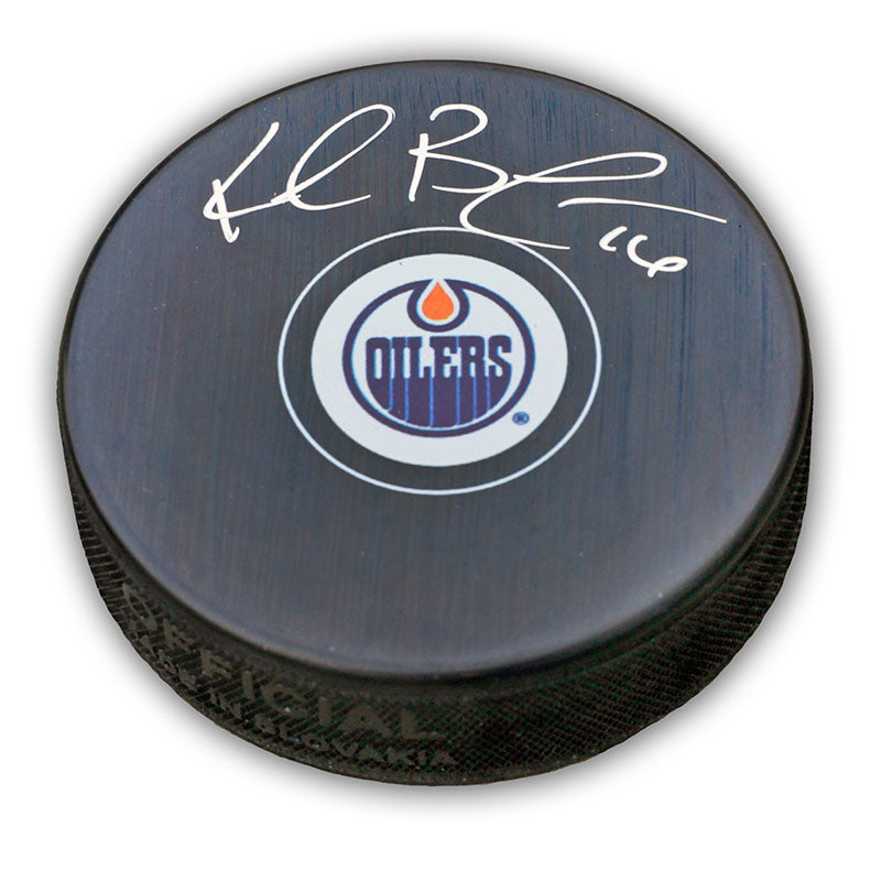 Black NHL hockey puck with Edmonton Oilers logo; puck is signed by Kelly Buchberger. 
