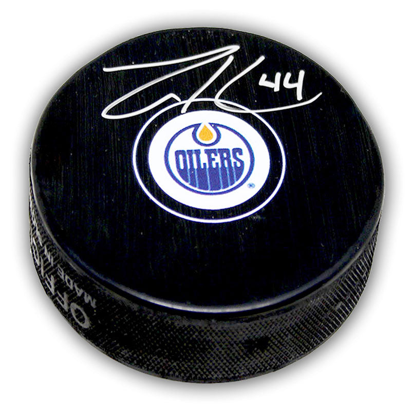 Black NHL hockey puck with Edmonton Oilers logo, puck is signed by Zack Kassian. 