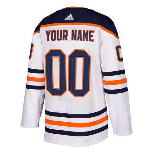 Back view of white Edmonton Oilers away road NHL jersey with navy shoulders, navy and orange stripes on sleeves and hem; jersey numbers read "00" and the name bar reads "your name"
